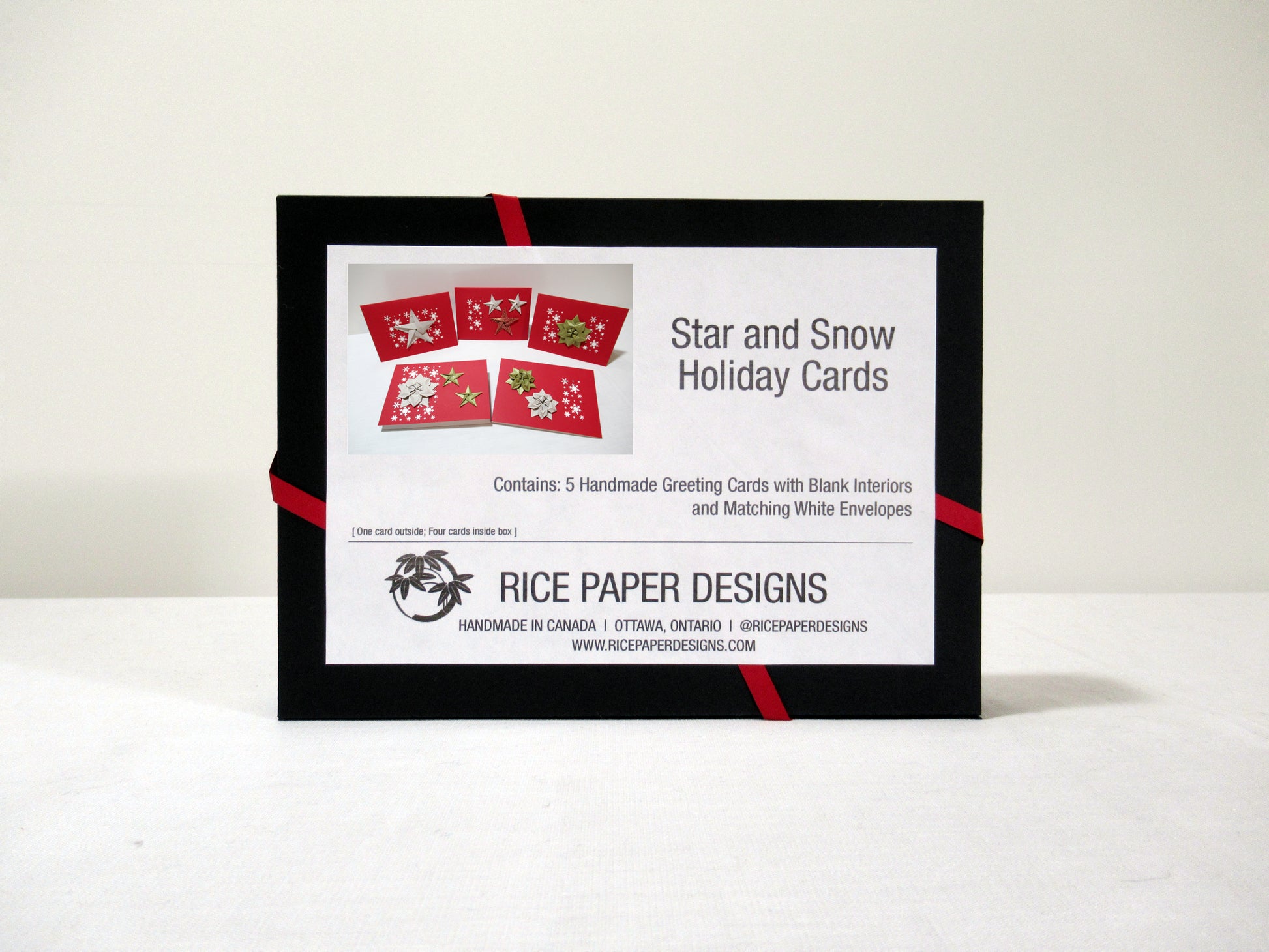 The back of a black box showing a label for a collection of Star and Snow Holiday Cards with product information and the Rice Paper Designs logo.
