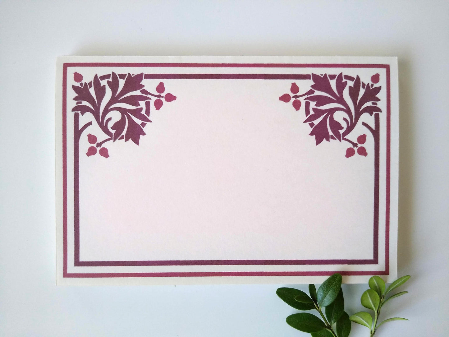 A single notepad with a stylized sassafras leaf design in both upper corners. There is a double line border around the whole notepad. Two small sprigs of leaves rest under the upper left hand corner.